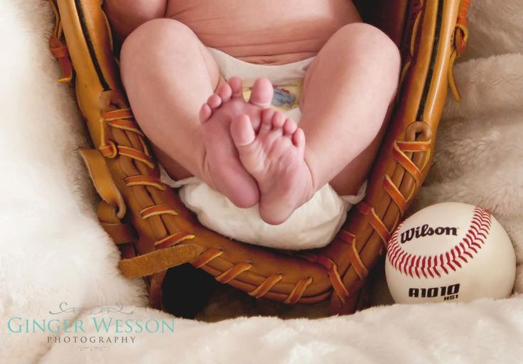 a baby sitting in a basket next to a baseball