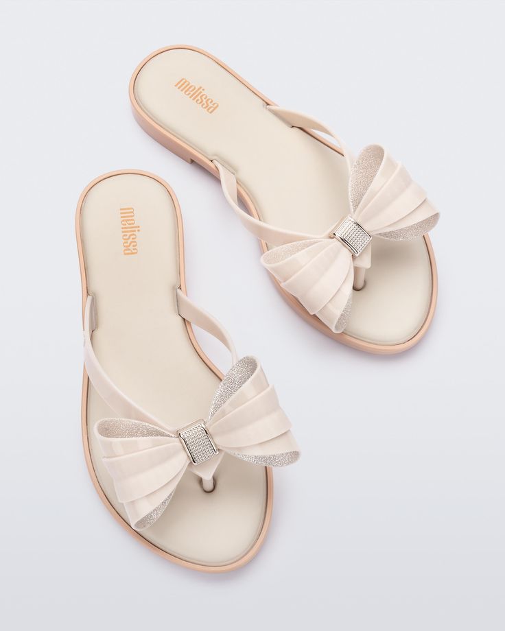 So lovely and luxe, the Slim Flip Flop brings bows to chic poolside style. Featuring a cushy footbed, metallic details and of course, ultra cute bow embellishments, slip these feminine flip flops on when you fancy some extra flair for a casual look. A little glam gets a lot of comfort. Casual Summer Flip Flops With Bow, Summer Bow Flip Flops With Open Toe, Summer Beach Flip Flops With Bow, Trendy Beach Sandals With Bow, Trendy Synthetic Sandals With Bow, Feminine Synthetic Sandals With Bow, Chic Flat Flip Flops For Party, Chic Party Flat Flip Flops, Chic Synthetic Flip Flops For Party