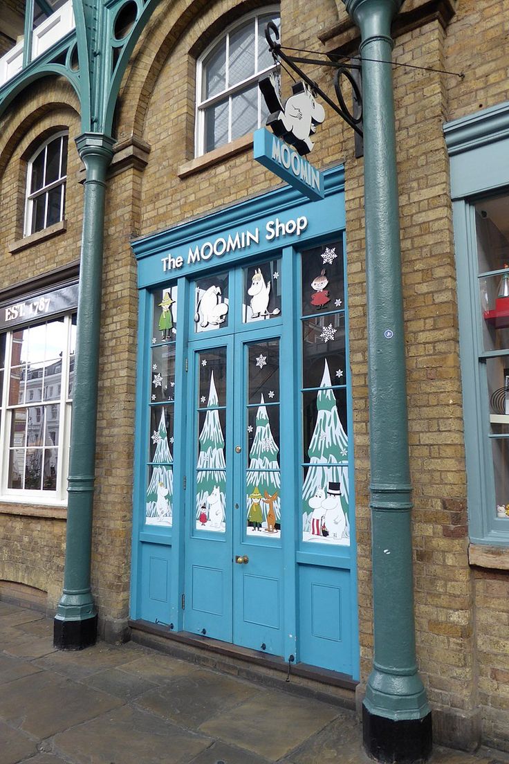 a blue store front with christmas decorations on the windows