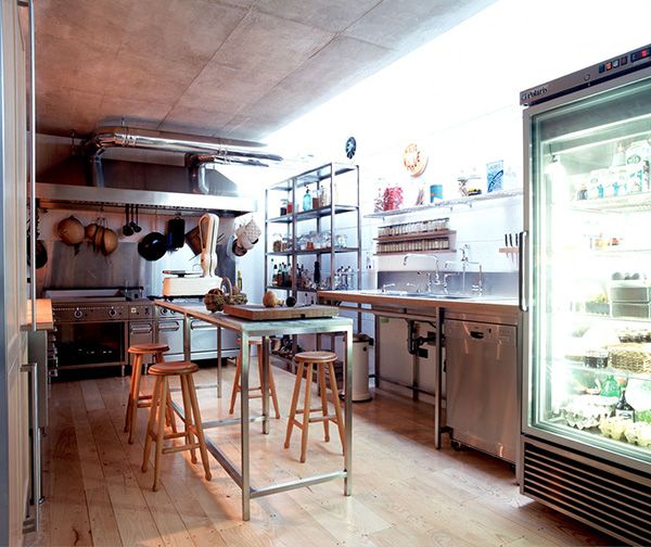 an industrial kitchen with stainless steel appliances and wood flooring is pictured in this image