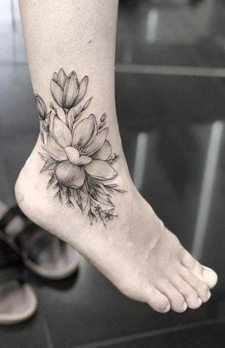 a woman's foot with a flower tattoo on it