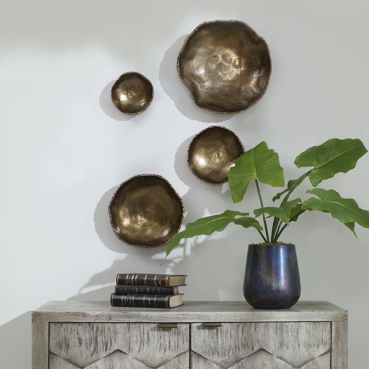 a plant in a vase sitting on top of a dresser