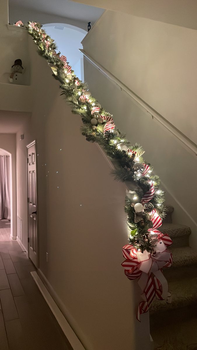 the christmas garland is hanging down the stairs