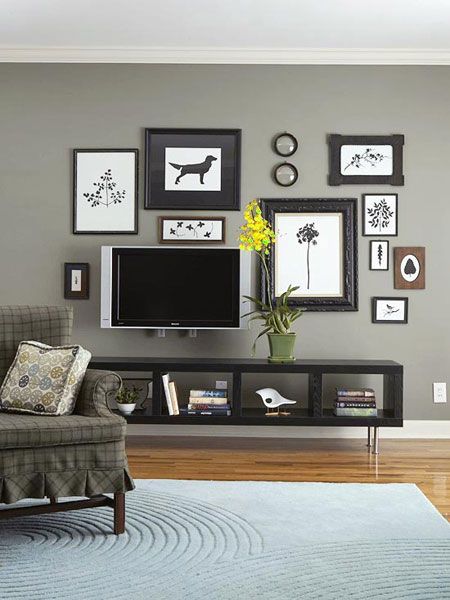 a living room with gray walls and pictures on the wall