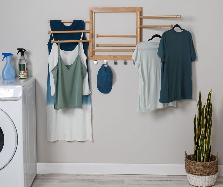 a washer, dryer and clothes hanging on the wall