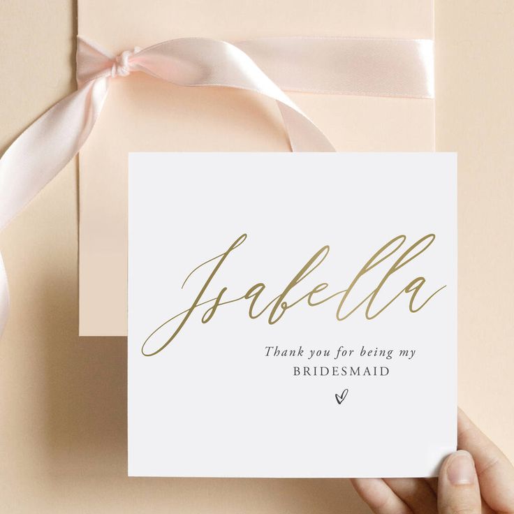 the bridesmaid card is being held in front of a white envelope with pink ribbon