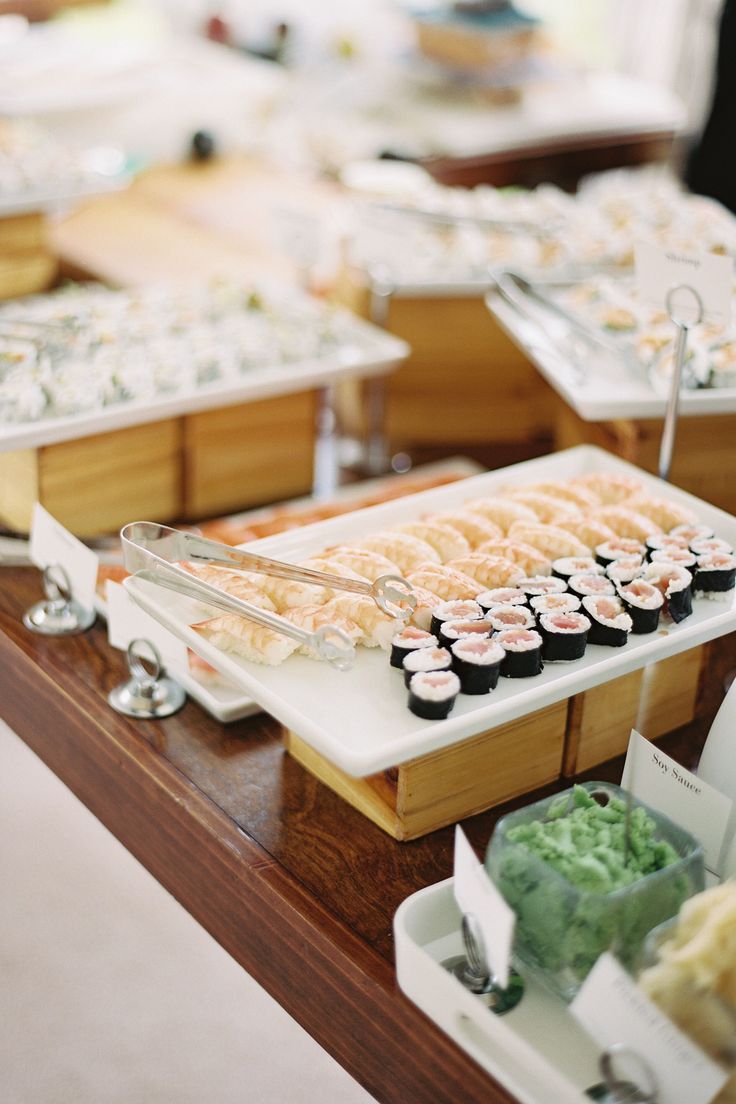 an assortment of sushi and other food items on a buffet table at a restaurant