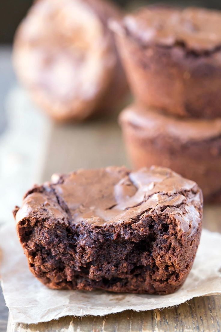 two chocolate muffins sitting on top of a piece of paper