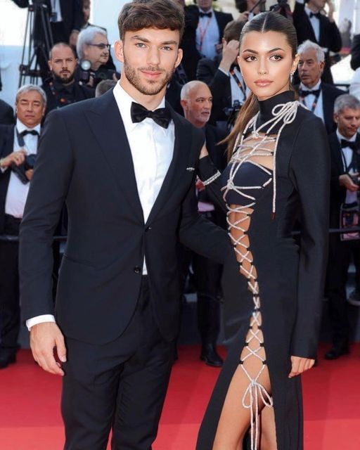 a man and woman standing next to each other in front of photographers on the red carpet