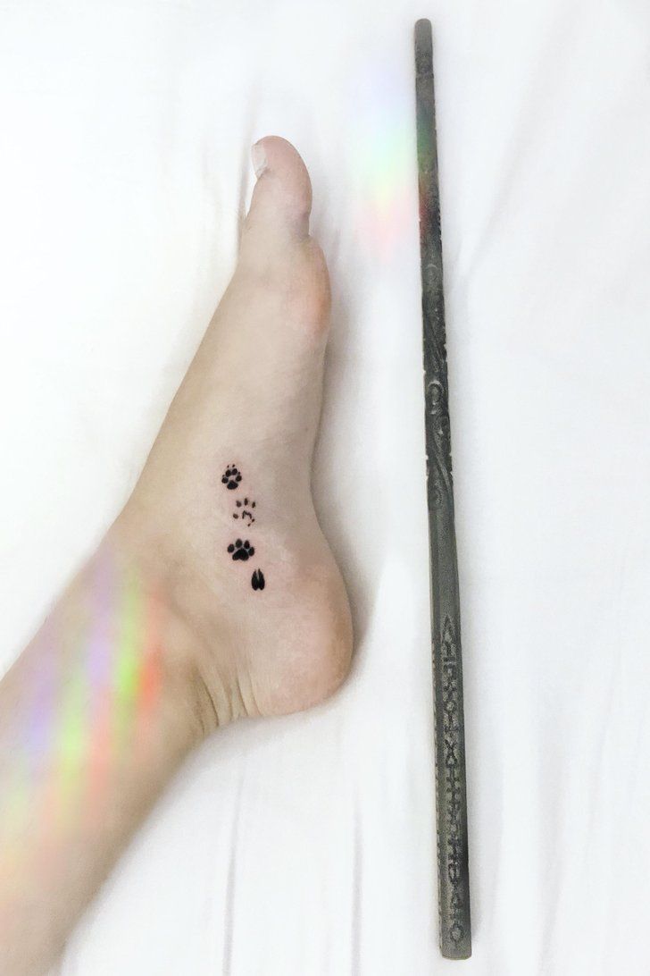 a person's foot with small paw prints on it and a pencil in the foreground