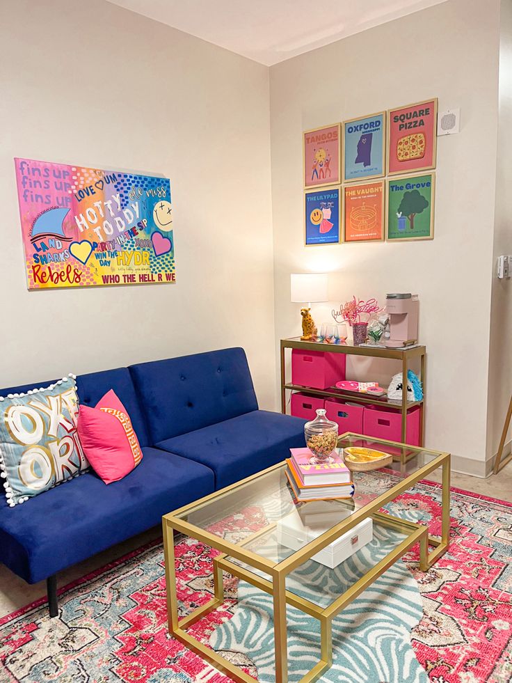 a living room with a blue couch and colorful rug on the floor in front of it