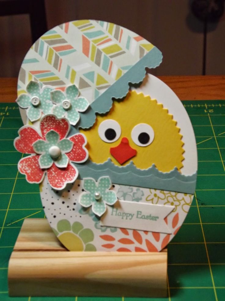 a close up of a paper crafting object on a cutting board with a green background