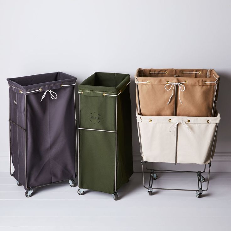 three different colored storage bins sitting next to each other on top of a white floor