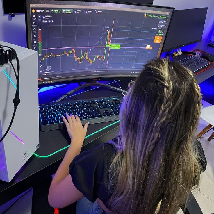 a woman sitting in front of a computer monitor