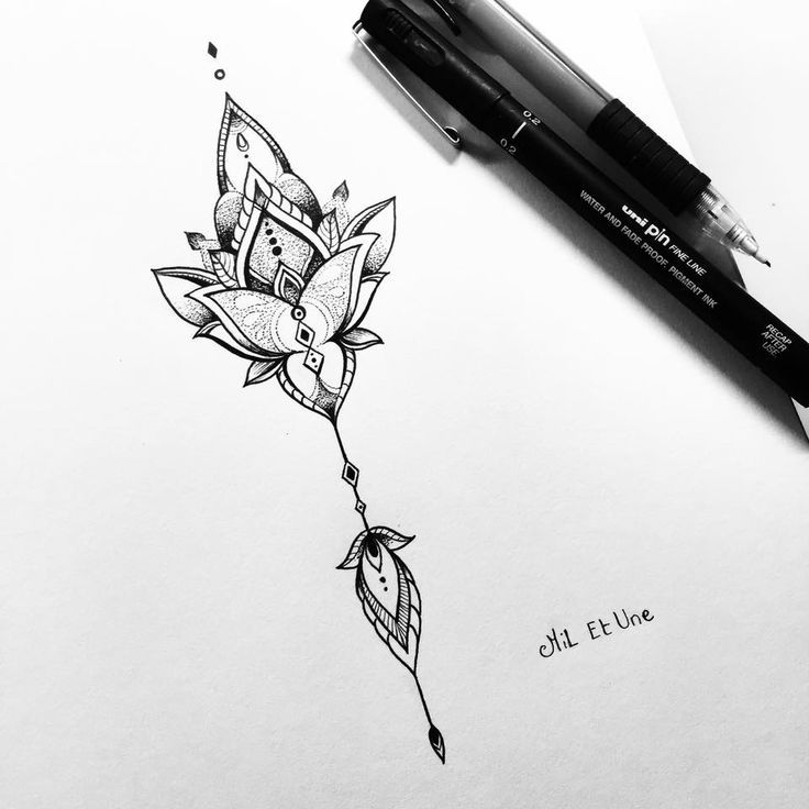 a drawing of a flower on paper next to a pen