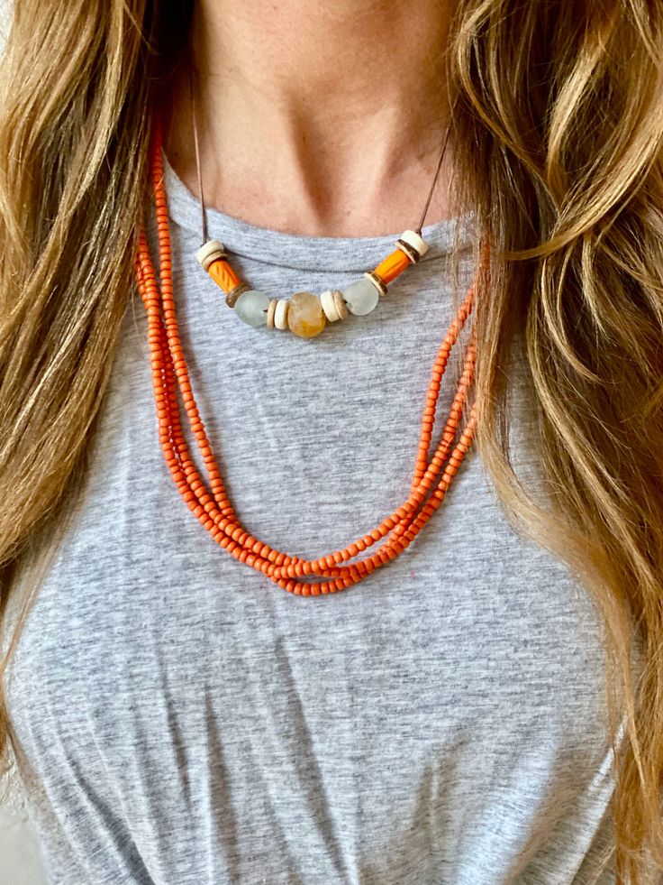 Our Layers are handmade by the women of Ghana - hand picked by Twine & Twig Set of 3.Please reference secondary images for the approximate length of necklace. Bohemian Hand-strung Necklaces For Layering, Fair Trade Unique Beaded Necklaces, Orange Fair Trade Jewelry Gift, Everyday Handmade Multi-strand Jewelry, Fair Trade Orange Jewelry Gift, Beaded Bohemian Necklaces, Artisan Single Strand Orange Beaded Necklace, Bohemian Orange Hand-strung Necklace, Handmade White Necklace For Everyday