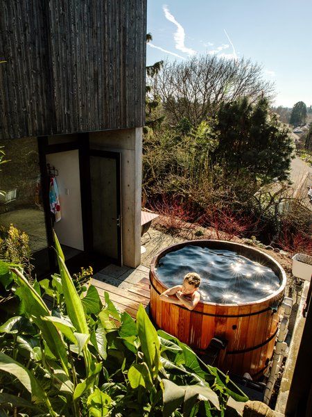 a wooden hot tub sitting next to a building