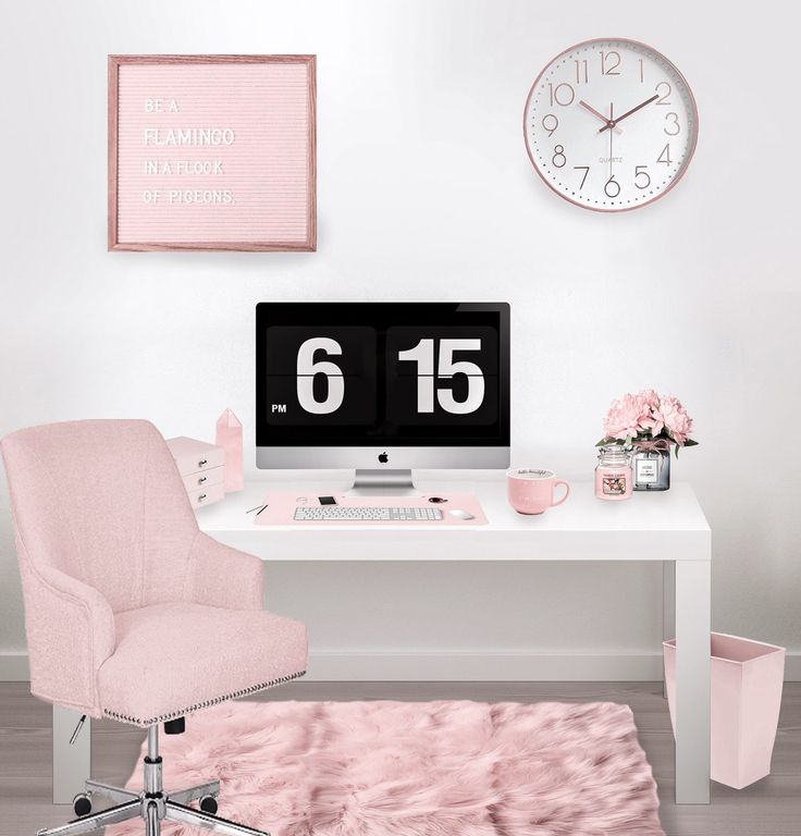 a white desk topped with a computer monitor next to a pink chair and wall clock