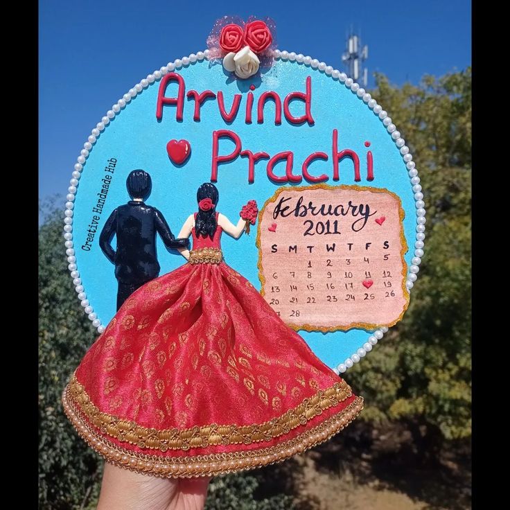 a hand holding up a calendar shaped like a bride and groom