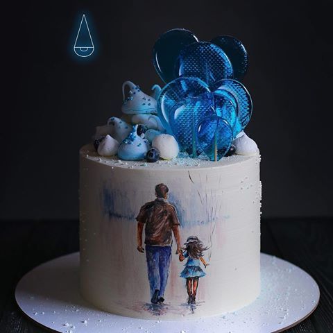 a white cake with blue frosting and an image of a man and woman holding hands