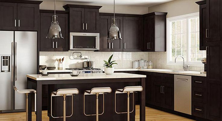 a modern kitchen with stainless steel appliances and dark wood cabinetry, along with bar stools