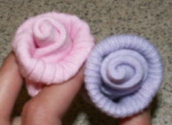 two small pink and blue hair clips in someone's hand