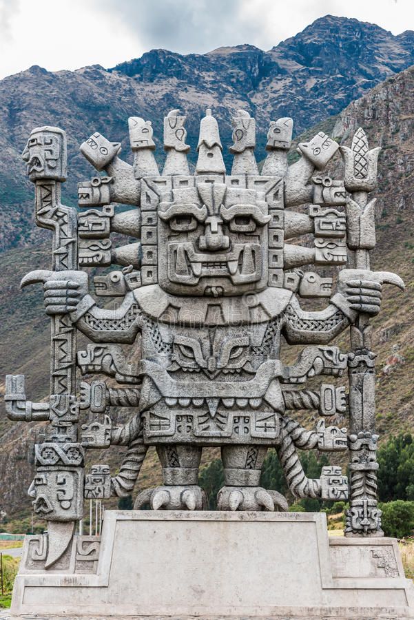 an elaborate statue in the shape of a face with many arms and legs, surrounded by mountains