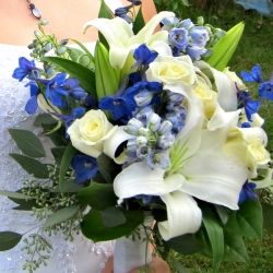 a bride holding a bouquet of white and blue flowers