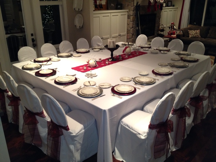 a dining room table set with white chairs and place settings for eight people, ready to be served