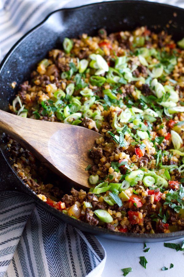 a skillet filled with food and a wooden spoon