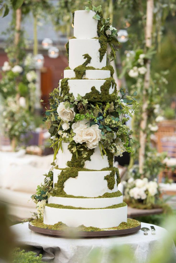 a wedding cake with white flowers and greenery