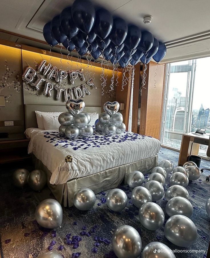 balloons floating in the air over a bed with a large number on it's headboard