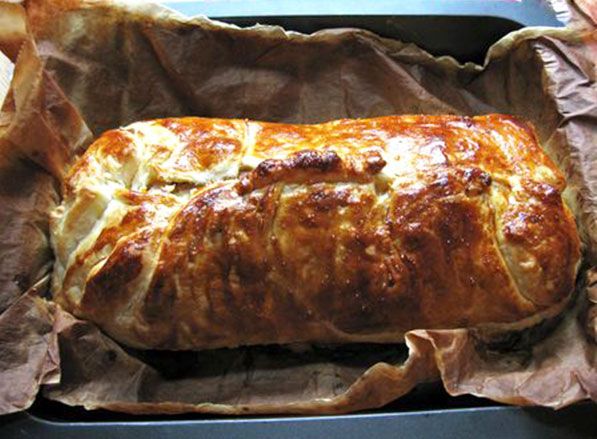 a loaf of bread sitting on top of a piece of wax paper in a pan