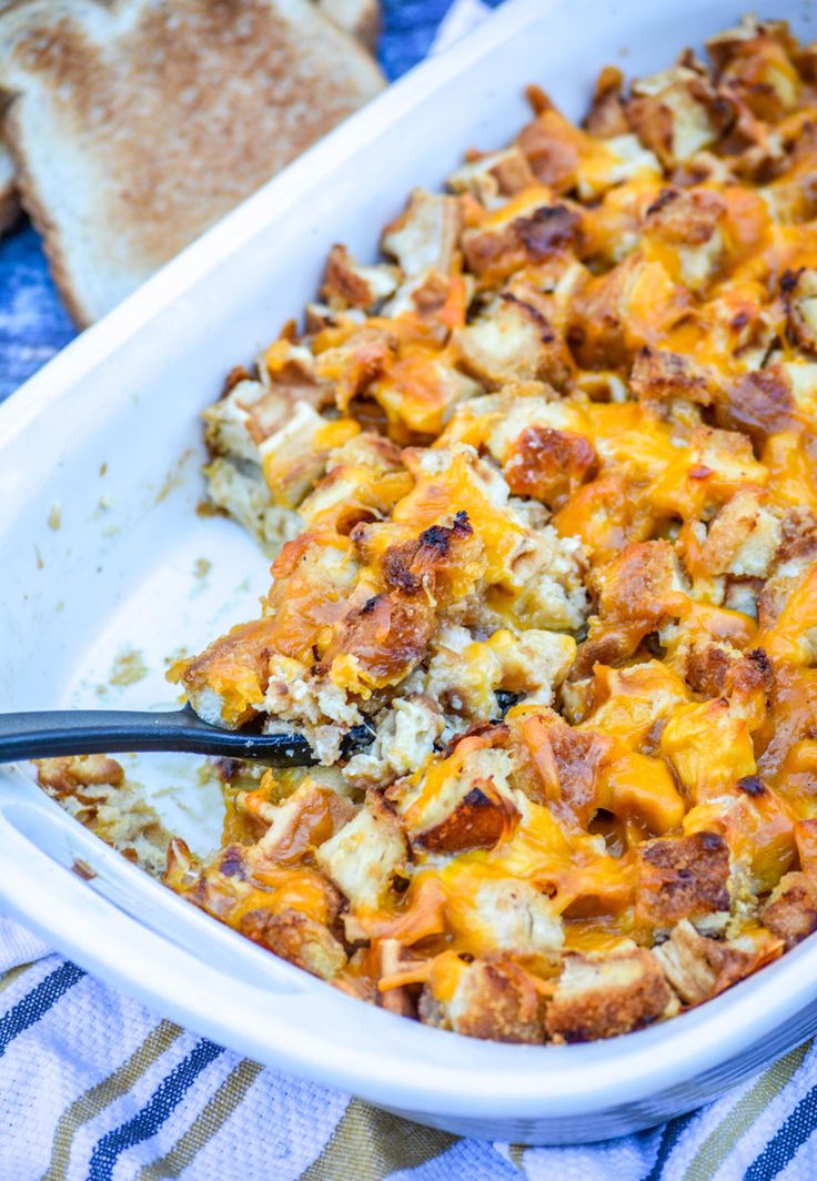 a casserole dish with bread and cheese in it on a blue table cloth