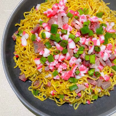 a bowl filled with noodles and veggies on top of a white countertop