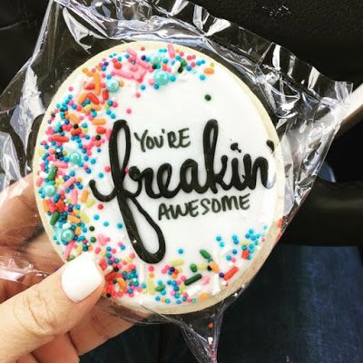 someone is holding up a cake with the words you're freakin awesome on it