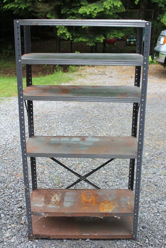 an old metal shelving unit sitting on gravel