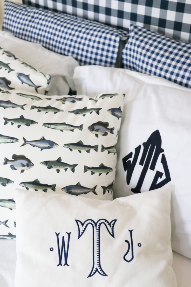 pillows with monogrammed fish on them and the letter tw are placed next to each other