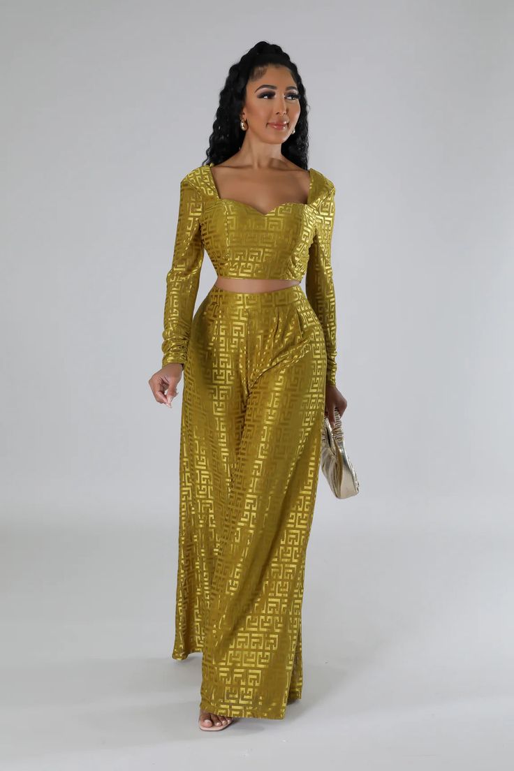 a woman wearing a gold dress and matching heels is standing in front of a white background