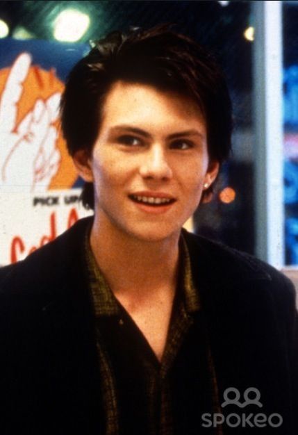 the young man is posing for a photo in front of a neon sign with his name written on it