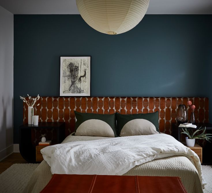 a bedroom with blue walls and white bedding