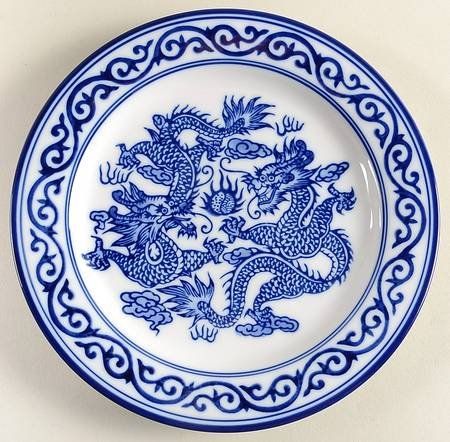 a blue and white plate with two dragon on it