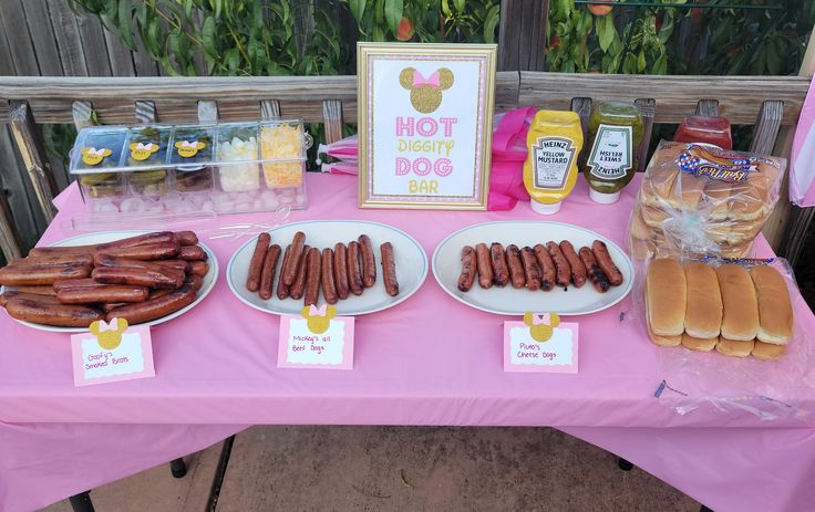 hot dogs and buns are on the table at a mickey mouse themed birthday party