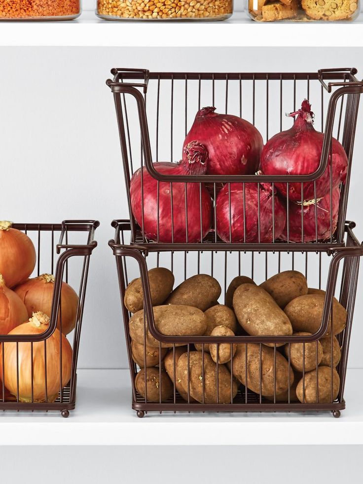 three wire baskets filled with potatoes and onions