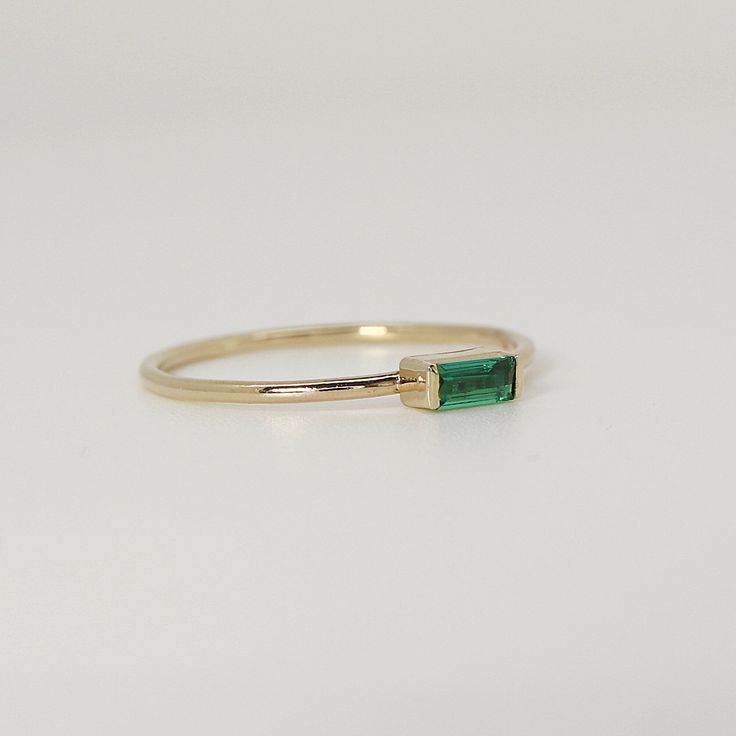 This beautiful baguette emerald Gold Ring was handmade in Melt'm Jewelry Design Studio in California using 14k solid yellow gold band and 4 x 2mm baguette lab grown emerald stone. DETAILS ABOUT THE RING, MATERIAL AND STONES Ring Band: 14K solid gold Ring Band size: 1 mm thick Gemstone: Lab Grown Emerald Emerald size: 4 mmx 2 mm baguette cut It is a great birthday gift for your special ones whose birthday are in May, since Emerald is May birthstone. This solid gold ring makes a perfect present fo Emerald Gold Ring, Gold Ring Band, Jewelry Design Studio, Solid Gold Ring, Gold Band Ring, Solid Gold Rings, Great Birthday Gifts, Emerald Stone, Baguette Cut