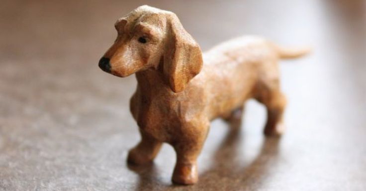 a small wooden toy dog standing on top of a table