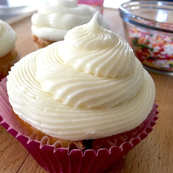 three cupcakes sitting on top of a wooden table