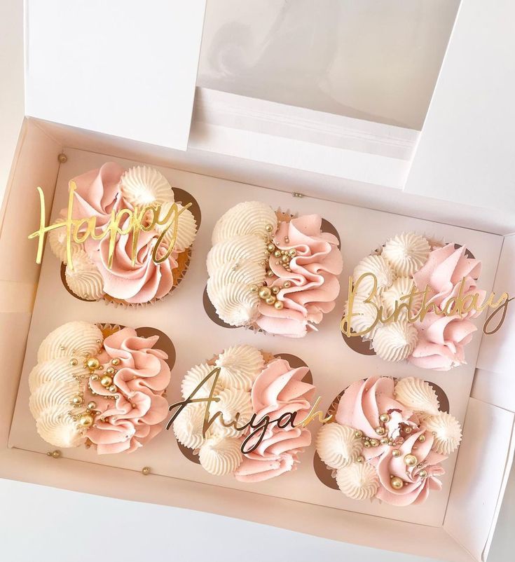 the cupcakes are decorated with pink and gold icing, along with personalized handwritten letters