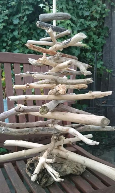 a tree made out of driftwood sitting on top of a wooden bench