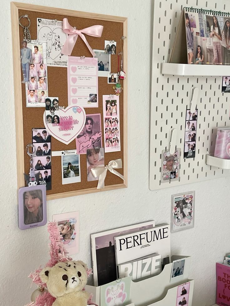 a teddy bear is sitting on a desk with many pictures and magnets attached to the wall